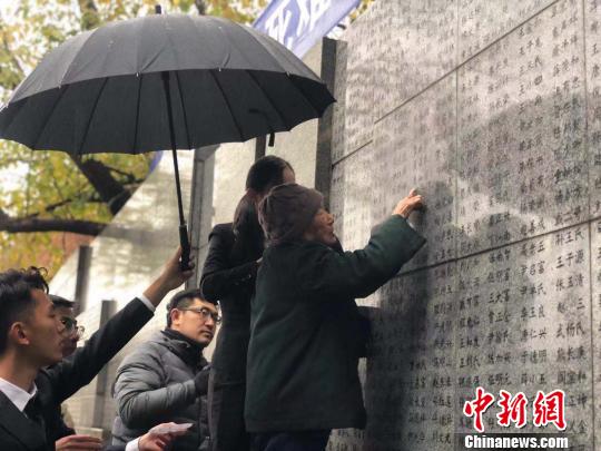 夏淑琴老人用手撫摸著親人的名字。　朱曉穎 攝
