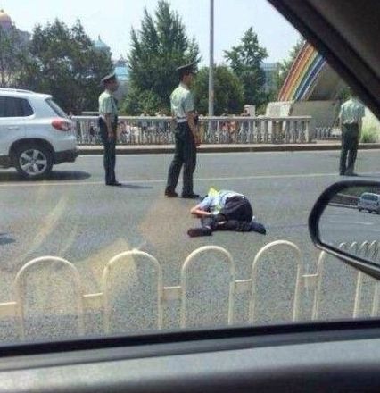 交警被撞出大概10米左右，趴在地上一動不動。